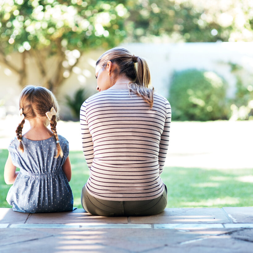 Rearview shot of a young woman and her daughter having a conversation on the porch